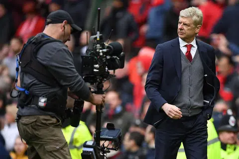 GIGIT JARI: Pengurus Arsenal, Arsene Wenger (kanan), meninggalkan padang pada akhir perlawanan Liga Perdana England di Old Trafford antara pasukannya dengan Manchester United yang berakhir dengan kekalahan anak buahnya 1-2. - Foto AFP