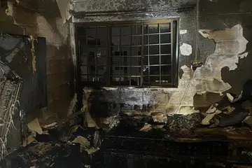 Anggota bomba SCDF memadamkan kebakaran, yang melibatkan kandungan sebuah bilik tidur, menggunakan pancutan air.