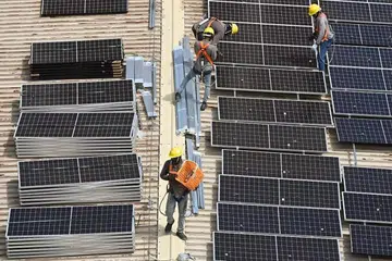TENAGA BERSIH: Para pekerja memasang panel suria di bumbung blok  HDB di Tampines. 
