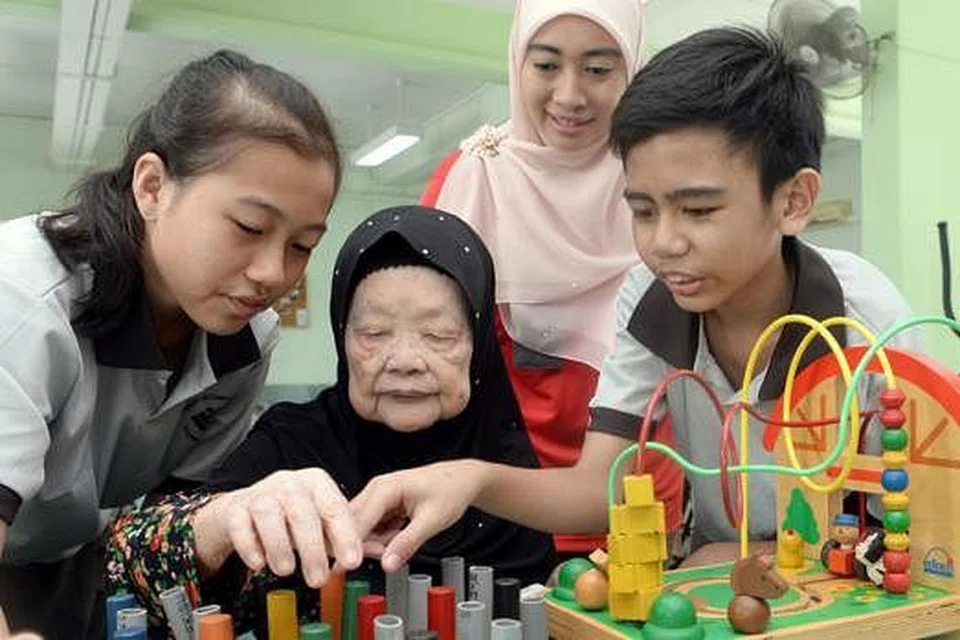 RAMAH MESRA: Pelajar menengah tiga Sekolah Menengah Yuhua, Auwaliin Ardha Mohd Ridwan (kiri) dan Arsh Lutfi Mohd Latiff, meluangkan masa bersama Hajah Fatimah Ismail (tengah) dan ramai warga emas lain. Turut memerhatikan ialah guru mereka, Cik Huzaimah Hamzah. - Foto TAUFIK A. KADER