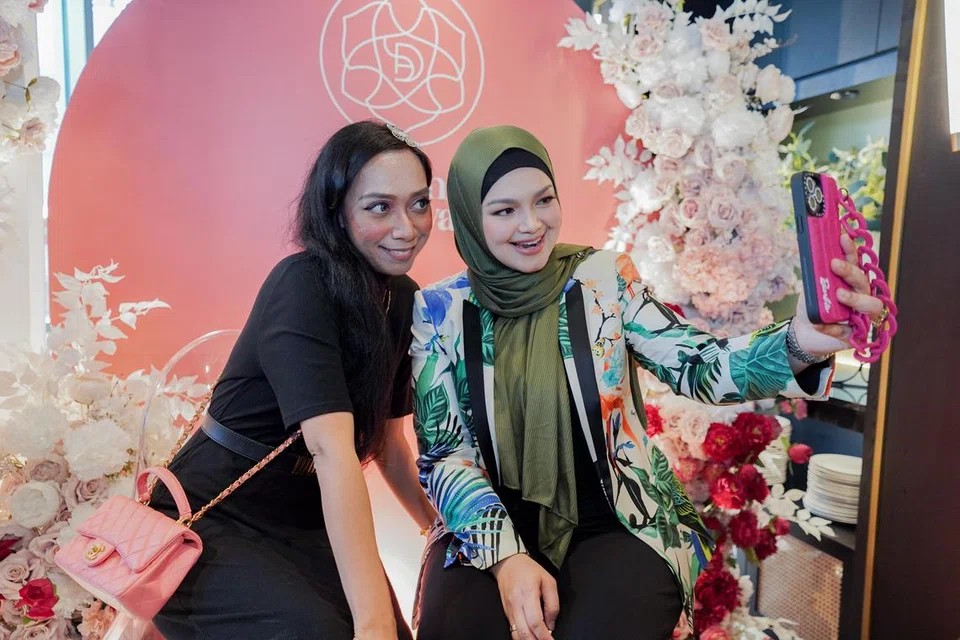 BERGAMBAR BERSAMA PEMINAT: Peminat Datuk Siti, Cik Fatihah Johari (kiri), berpeluang bergambar bersama penyanyi kesayangan ramai.