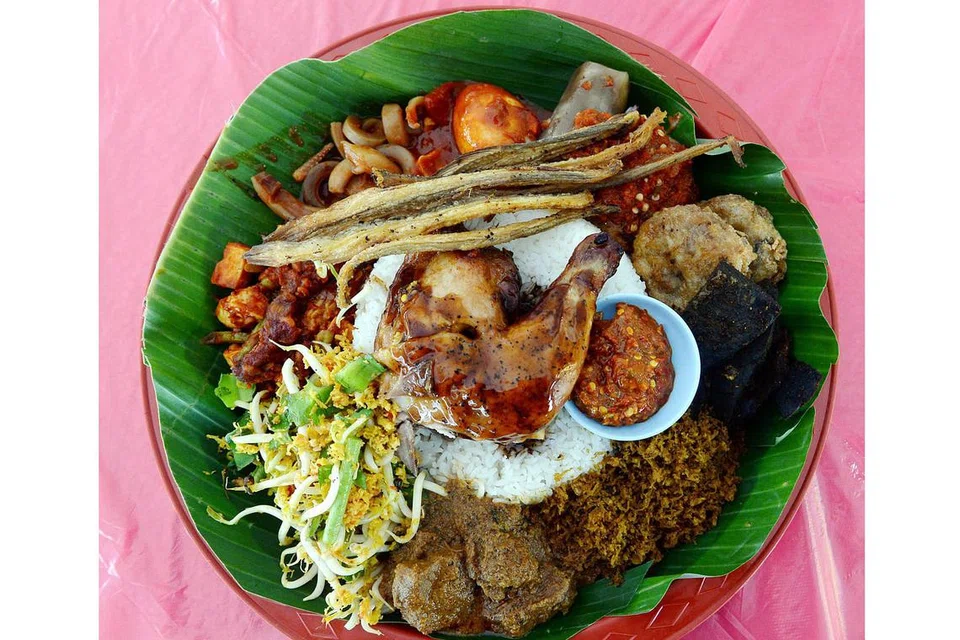 PASTI JILAT JARI: Selepas habis makan, memang menjadi kebiasaan sesetengah orang kita yang makan menggunakan tangan, menjilat jari jemari mereka, apatah lagi selepas makan nasi ambeng. - Foto fail 