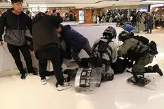 AMBIL TINDAKAN: Polis rusuhan Hong Kong menahan penunjuk perasaan dalam sebuah perhimpunan pada Krismas di pusat beli-belah Sha Tin. - Foto REUTERS