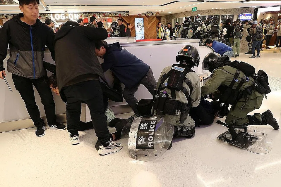 AMBIL TINDAKAN: Polis rusuhan Hong Kong menahan penunjuk perasaan dalam sebuah perhimpunan pada Krismas di pusat beli-belah Sha Tin. - Foto REUTERS