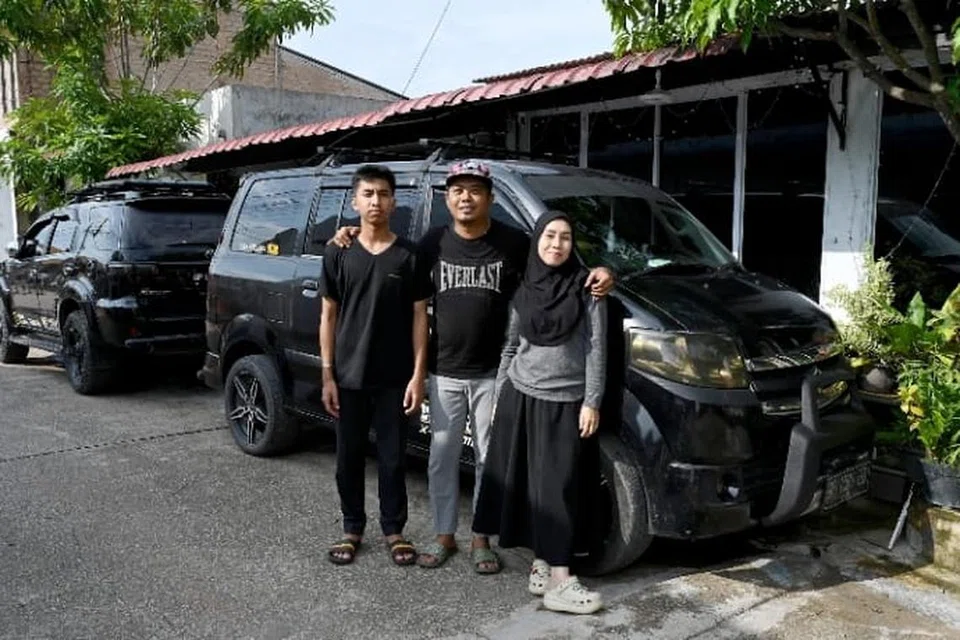 Warga Singapura, Encik Shaiful Saad, 47 tahun, bersama isterinya, Cik Nia Tutira, 40 tahun, dan anak lelaki mereka di hadapan rumah mereka di daerah Tiban, Batam.