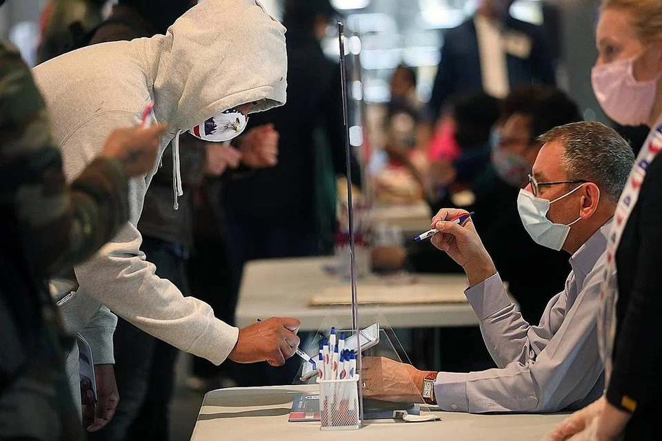 KEPERLUAN MEMAKAI PELITUP: Para pengundi awal dilihat memakai pelitup semasa mengundi di pusat-pusat mengundi di New York City menjelang Hari Mengundi pada 3 November ini. - Foto AFP
