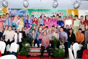 HUBUNGAN PEKERJA: Haji Taha (baju kurung ungu, tengah bersongkok), yang bergambar bersama sebahagian daripada pekerjanya di Batam, menganjurkan acara berkumpul untuk eratkan hubungan dengan pekerja di sana. - Foto DUTA FREIGHT INTERNATIONAL PTE LTD