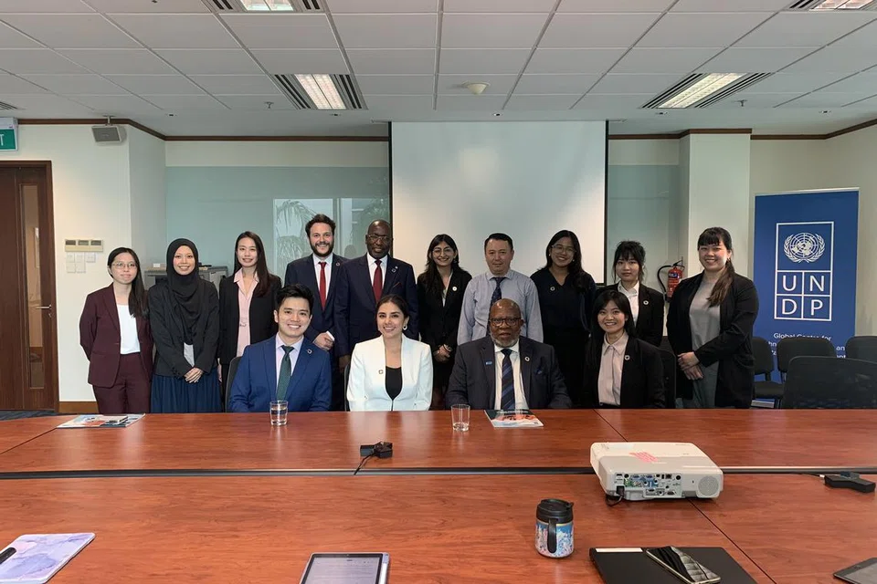 Cik Khairunnisa Yahya (dua dari kiri) di pejabat (Rancangan Pembangunan Pertubuhan Bangsa-Bangsa Bersatu (UNDP) Singapura bersama mantan Presiden Perhimpunan Agung Pertubuhan Bangsa-Bangsa Bersatu (UN), Encik Dennis Francis, semasa beliau berkunjung ke Singapura pada Julai 2024.
