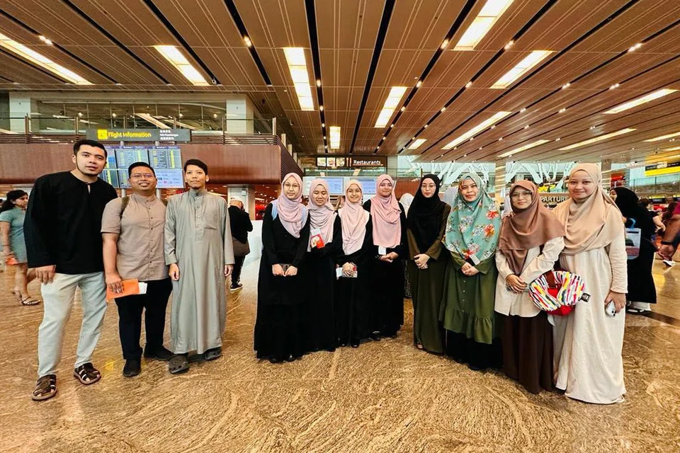 BERLPAS: Pasukan Singapura Kejohanan Debat Sekolah Antarabangsa Qatar 2023 (tengah, berbaju hitam) bergambar dengan jurulatih dari Munazarah SG di Lapangan Terbang Changi.
