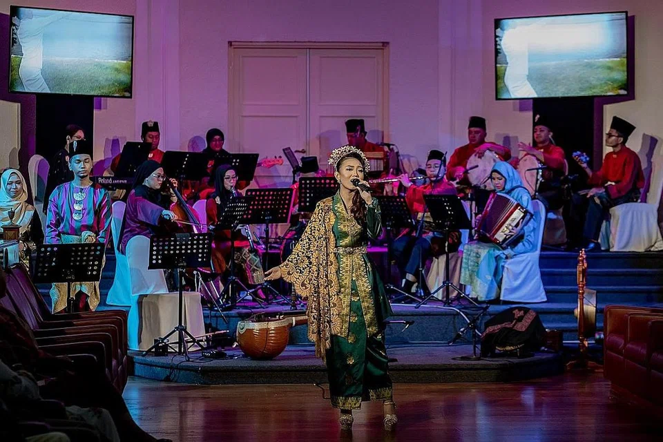 KENANGAN MENGUSIK JIWA: Herna Sabrina (di tengah, menyanyi) membawa kesyahduan lagu 'Di Tanjong Katong' di ruang Chamber, The Arts House, dengan iringan muzik Gendang Akustika yang dipimpin Syafiqah 'Adha Sallehin (pemain akordion). - Foto BH oleh NUR DIYANA TAHA