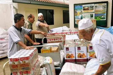 SIBUK DI DAPUR: Kakitangan dan sukarelawan Masjid Khalid memeriksa bekalan makanan untuk dijadikan juadah berbuka sepanjang Ramadan. - Foto KHALID BABA