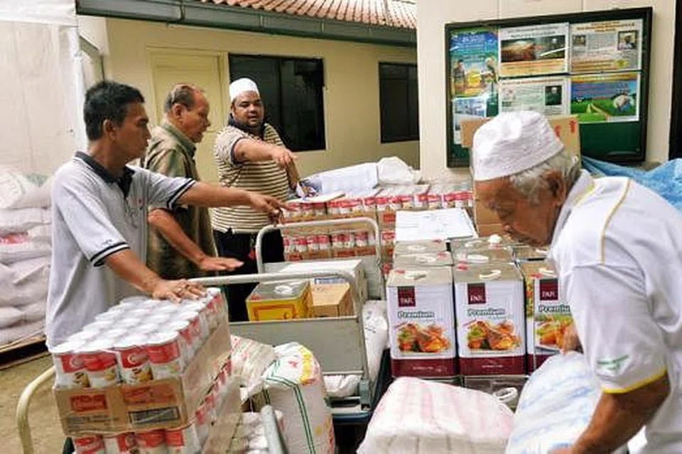 SIBUK DI DAPUR: Kakitangan dan sukarelawan Masjid Khalid memeriksa bekalan makanan untuk dijadikan juadah berbuka sepanjang Ramadan. - Foto KHALID BABA