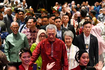 Menteri Kanan, Encik Lee Hsien Loong (berbaju merah), dan isteri, Cik Ho Ching (baju putih), disambut dengan tepukan gemuruh dalam majlis jamuan makan malam anjuran masyarakat Melayu/Islam. Majlis di Singapore Expo pada 20 September itu turut dihadiri Encik Masagos Zulkifli Masagos Mohamad (berbaju hijau).