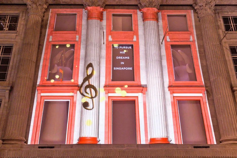 PERSEMBAHAN UNIK: Encik Safuan Johari, kurator bersama projek persembahan pancaran lampu, Art Skins on Monuments, sebahagian daripada Festival 'Light to Night' edisi Bicentennial Singapura, bertanggungjawab mempamerkan 'Sayang di Sayang' yang dipancarkan di Padang Atrium di Galeri Nasional Singapura (gambar atas). Ia menceritakan perjalanan Allahyarham Zubir Said daripada seorang pemuzik muda di Sumatera, Indonesia, yang kemudian menjadi komposer lagu kebangsaan Singapura. - Foto GALERI NASIONAL SINGAPURA