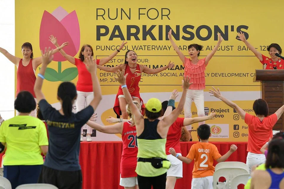 BERSENAM DAHULU: Peserta diajak melakukan senaman ringkas zumba sebelum memulakan larian amal di Taman Waterway Punggol semalam. - Foto BH oleh LIM YAOHUI
