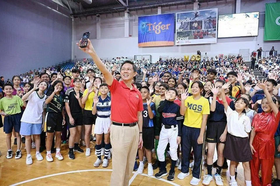 Menteri Pendidikan Chan Chun Sing bergambar bersama atlet pelajar selepas membuka NSG 2024 secara rasmi di Arena OCBC pada 30 Januari.
