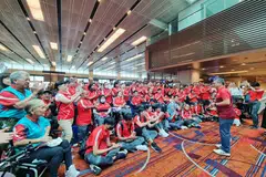 SEMOGA BERJAYA: Menteri Kebudayaan, Masyarakat dan Belia merangkap Menteri Kedua Undang-Undang, Encik Edwin Tong (berdiri, memandang para atlet), hadir di Lapangan Terbang Changi untuk menghantar para atlet. 