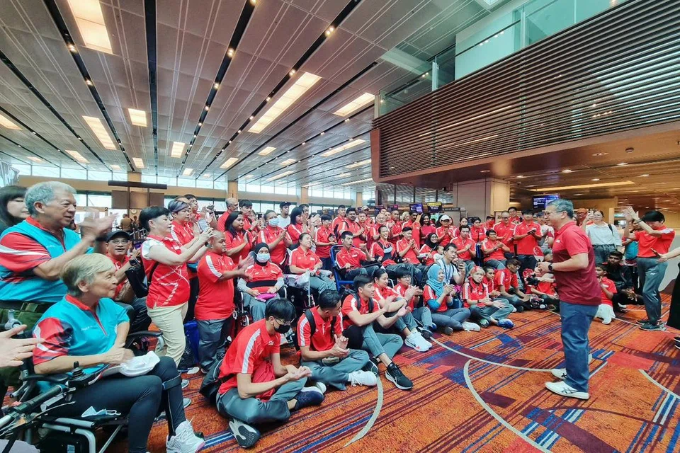 SEMOGA BERJAYA: Menteri Kebudayaan, Masyarakat dan Belia merangkap Menteri Kedua Undang-Undang, Encik Edwin Tong (berdiri, memandang para atlet), hadir di Lapangan Terbang Changi untuk menghantar para atlet. 