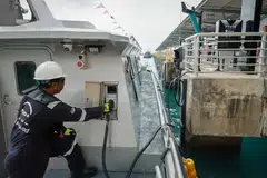Seorang pekerja mengecas Pyxis X Tron, kapal penumpang elektrik sepenuhnya, yang berlabuh di Marina South Pier pada 8 April 2024.