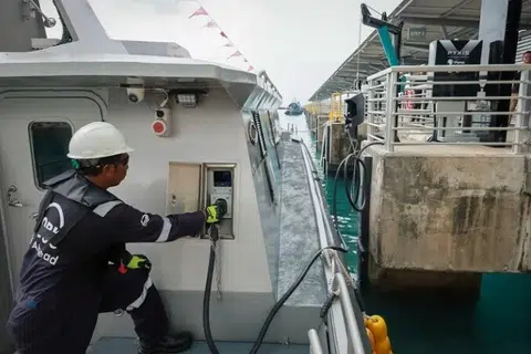 Seorang pekerja mengecas Pyxis X Tron, kapal penumpang elektrik sepenuhnya, yang berlabuh di Marina South Pier pada 8 April 2024.