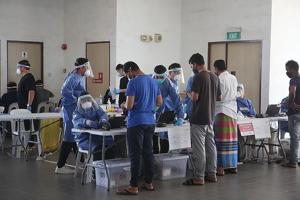 TANGKAS BERTINDAK: Pekerja asing di sebuah dormitori di Tuas dibantu menjalani ujian Covid-19. Agensi awam tangkas dalam beralih daripada peranan sebelum pandemik kepada peranan kecemasan baru yang menyaksikan mereka meningkatkan operasi dengan ketara dan pantas semasa pandemik Covid-19 melanda, kata Kementerian Kewangan (MOF). - Foto fail