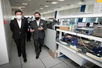 LAWAT SYARIKAT: Encik Chan Chun Sing mendengar taklimat dari Pengarah Urusan Rohde and Schwarz, Encik Andy Goh (kanan), semasa lawatannya bagi meninjau khidmat dan huraian teknologi yang dibangunkan oleh kumpulan teknologi itu. - Foto ZAOBAO