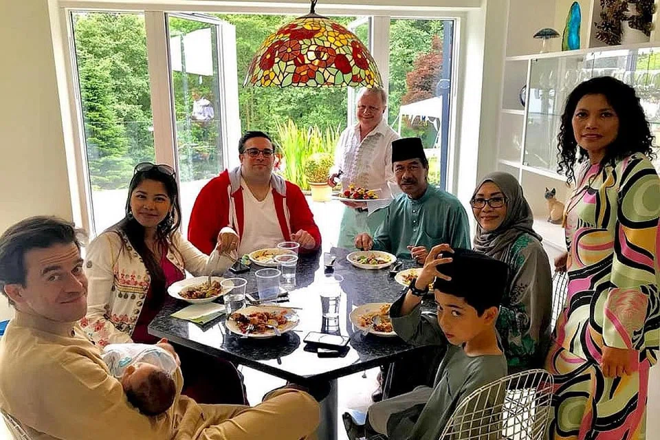 MELEPASKAN RINDU LEBARAN: Cik Kamsaton Kamis (bertudung) bersama suaminya, yang mahu dikenali sebagai Encik Hamid (bersongkok), meraikan Hari Raya bersama anak, menantu dan cucu mereka di London. - Foto ihsan KAMSATON KAMIS