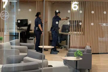 Seorang pegawai polis mengacukan pistolnya ke arah seorang lelaki yang bersenjatakan pisau di Pusat Sivik Woodlands pada pagi 27 Mac.