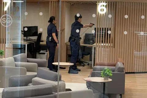 Seorang pegawai polis mengacukan pistolnya ke arah seorang lelaki yang bersenjatakan pisau di Pusat Sivik Woodlands pada pagi 27 Mac.