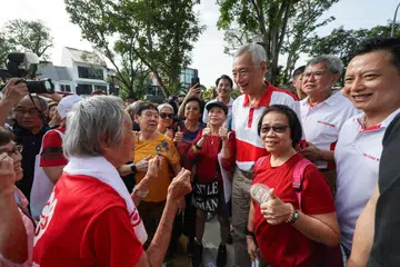 Menteri Kanan, Encik Lee Hsien Loong (empat dari kanan) bersama Anggota Parlimen SMC Yio Chu Kang, Encik Yip Hon Weng (paling kanan) bergambar dengan penduduk di Taman Permainan Fudu Walk semasa pelancaran Pusat Penduduk di estet Lentor pada 1 Disember.