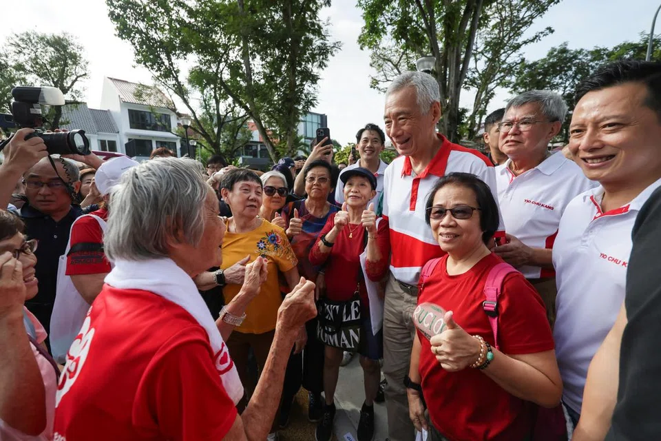 Menteri Kanan, Encik Lee Hsien Loong (empat dari kanan) bersama Anggota Parlimen SMC Yio Chu Kang, Encik Yip Hon Weng (paling kanan) bergambar dengan penduduk di Taman Permainan Fudu Walk semasa pelancaran Pusat Penduduk di estet Lentor pada 1 Disember.