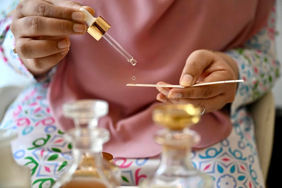 Cik Thahirah menunjukkan salah satu minyak wangi ditawarkan Thahirah Kazura, yang turut menyediakan khidmat menghasilkan wangian mengikut cita rasa pelanggan.