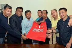 SAHUT CABARAN: Pengerusi Pasukan Bola Sepak Melayu Singapura (SMFT), Muhammad Zaki Ma'arof (tiga dari kiri), menghulurkan cenderahati kepada presiden Persatuan Bola Sepak Melayu Malaysia (PBSMM), Dato' Sri Wan Adnan Wan Mamat (tiga dari kanan), dalam pertemuan muhibah di sini minggu lalu. Bersama dalam gambar ialah pegawai utama kededua persatuan itu (dari kiri) timbalan ketua SMFT, Salman Abdullah; pengurus skuad Melayu Singapura, Shahri Rahim; timbalan ketua kedua SMFT, Razali Rashid; naib presiden PBSMM, Datuk Ramlan Askolani; dan di belakang ialah anggota majlis PBSMM, Mohd Zamri Mazleh. - Foto ZAINAL YAHYA