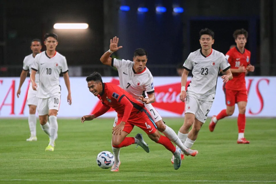 Akram (jersi merah) dan pemain Hong Kong, Soares Junior Walter, bergelut untuk menguasai bola semasa perlawanan kelayakan Piala Asia  Konfederasi Bola Sepak Asia (AFC) pada 25 Mac 2025 di Stadium Negara.