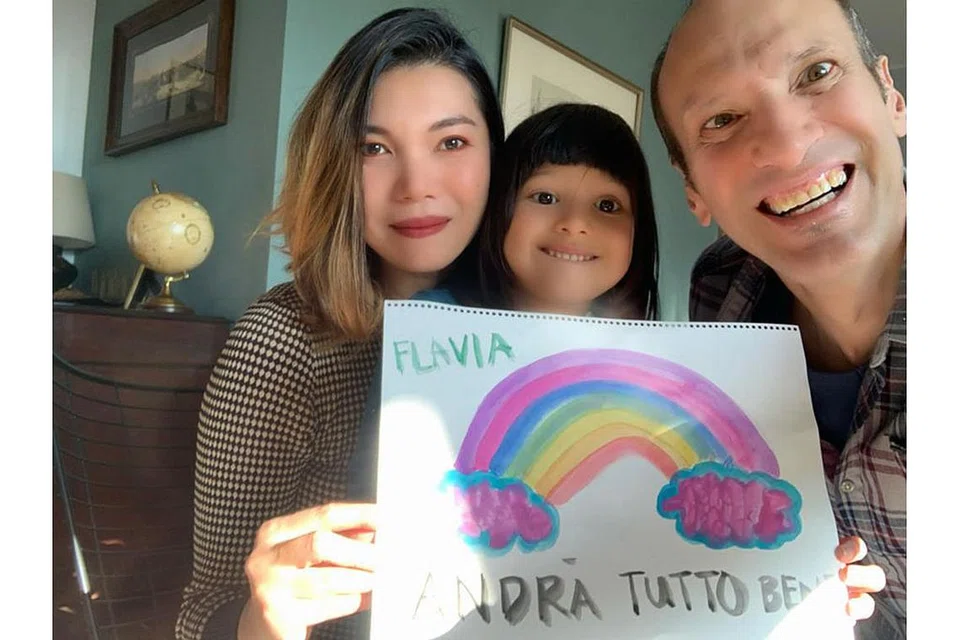 SEBAR MESEJ POSITIF: Si comel, Flavia (tengah), menunjukkan lukisan pelanginya dengan kekata 'Andra tutto bene' yang bererti 'Segalanya akan baik-baik sahaja'. Bersamanya ialah ibu bapanya, Cik Herlina dan Encik Fabio. - Foto ihsan HERLINA HALIM