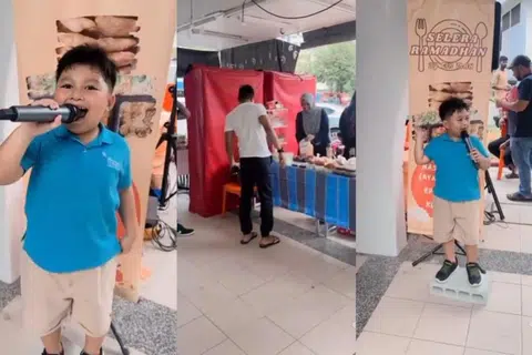 Murid Tadika 2 (K2), Affan Muhammad Amin, menggunakan mikrofon untuk mengajak orang ramai supaya membeli makanan dari gerai keluarganya, Selera Ramadhan by Cik Mah, di Blok 201D, Tampines Street 21.