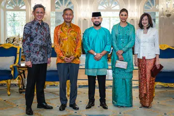 Pemangku Raja Johor, Tunku Ismail (tengah) dan isteri, Che’ Puan Mahkota Khaleeda Johor (dua dari kanan) menyambut  (dari kiri) Menteri Pendidikan, Encik Chan Chun Sing dan Menteri Ehwal Luar, Dr Vivian Balakrishnan serta isterinya, Cik Joy, pada acara Rumah Terbuka Hari Raya keluarga Diraja Johor pada 31 Mac. 