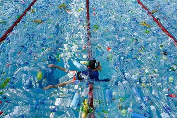 USAHA PERTINGKAT KESEDARAN: Seorang kanak-kanak berenang di kolam yang dipenuhi botol plastik semasa kempen kesedaran Hari Lautan Sedunia di Bangkok, Thailand. - Foto AFP 