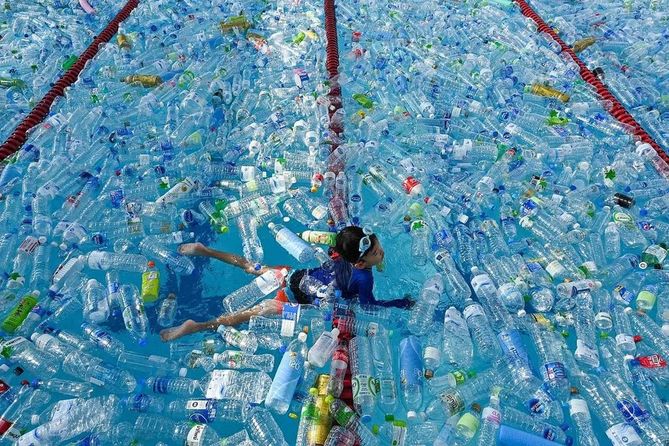 USAHA PERTINGKAT KESEDARAN: Seorang kanak-kanak berenang di kolam yang dipenuhi botol plastik semasa kempen kesedaran Hari Lautan Sedunia di Bangkok, Thailand. - Foto AFP 