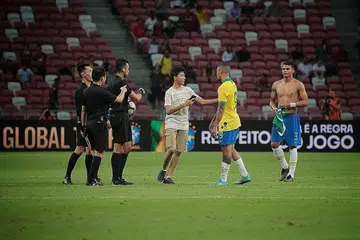 AMBIL KESEMPATAN: Seorang peminat muda cuba mengambil kesempatan bergambar dengan penyerang Brazil, Gabriel Jesus (jersi kuning), selepas dia mencerobohi padang di Stadium Negara ketika perlawanan antara Brazil dengan Senegal pada 10 Oktober lalu. - Foto BH oleh JASON QUAH