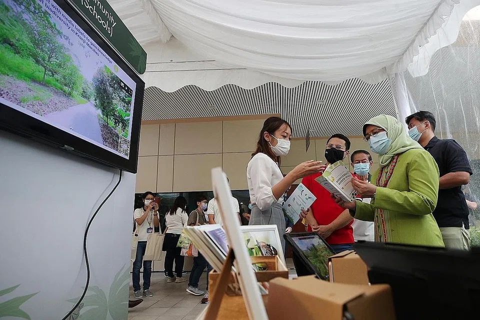LINDUNGI PANTAI: Presiden Halimah Yacob (dua dari kanan) dan Encik Desmond Lee (berbaju merah) menghadiri Pesta Biodiversiti yang diadakan di Kebun Bunga semalam. Di acara itu, NParks mengumumkan projek baru untuk melindungi pantai di Pulau Ubin. - Foto BM oleh TIMOTHY DAVID