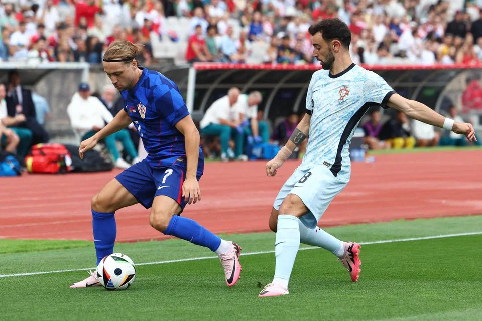 Kapten Portugal, Bruno Fernandes (kanan), cuba merebut bola daripada Lovro Majer dalam perlawanan persahabatan dengan Croatia di Stadium Centro Desportivo Nacional do Jamor pada 9 Jun lalu, yang menyaksikan pasukannya tewas 1-2.