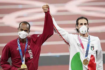 KONGSI KEMENANGAN: Daripada terus bersaing untuk mengalahkan satu sama lain, Mutaz Barshim (kiri) dan Gianmarco Tamberi bersetuju berkongsi tempat nombor satu acara lompat tinggi lelaki. - Foto EPA-EFE