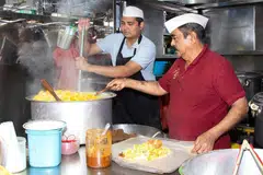 Seorang pegerai menjual nasi beriani di pusat jaja makanan Geylang Serai. 