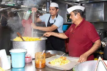 Seorang pegerai menjual nasi beriani di pusat jaja makanan Geylang Serai. 