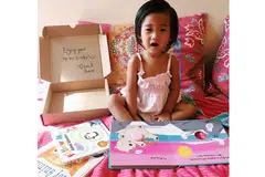TERIMA HADIAH BUKU: Hanan Inara membelek buku yang diterimanya daripada Josh & Cherie yang menghantar kotak langganan buku bagi kanak-kanak kepada pelanggan setiap bulan. - Foto ihsan AMANINA ZAFIRAH CHUA
