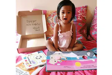 TERIMA HADIAH BUKU: Hanan Inara membelek buku yang diterimanya daripada Josh & Cherie yang menghantar kotak langganan buku bagi kanak-kanak kepada pelanggan setiap bulan. - Foto ihsan AMANINA ZAFIRAH CHUA