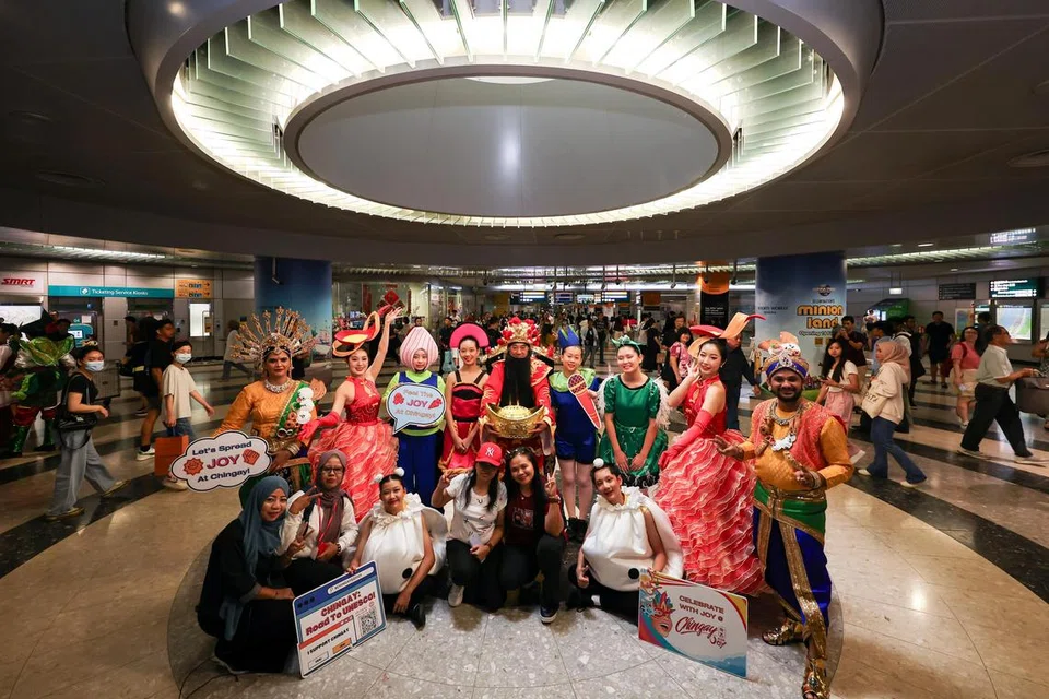 Para penumpang sempat merakamkan kenangan bergambar bersama peserta Chingay semasa acara praperarakan di Stesen MRT Bayfront pada 19 Januari.