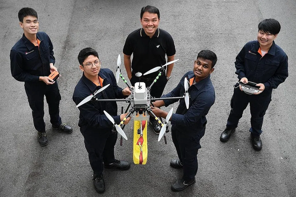 KUMPULAN MEMBINA DRON: Erhan Harith (kiri, baris bawah) berkata cabaran utama membina dron tersebut adalah aspek pemprogramannya. Bersama dalam gambar (di baris atas) ialah Stephen Ong, Encik Soh Kee Teck dan Kenneth Ng. (Baris bawah kanan) ialah Sanjay Shagaran. - Foto fail