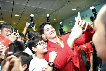 Perenang negara Joseph Schooling bergambar bersama para peminat selepas tiba di Lapangan Terbang Changi daripada Sukan Olimpik Rio 2016 pada pagi Isnin (15 Ogos).